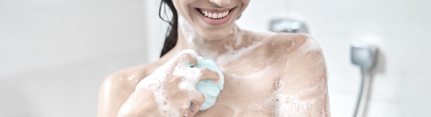 Mujer sonriendo mientras se ducha