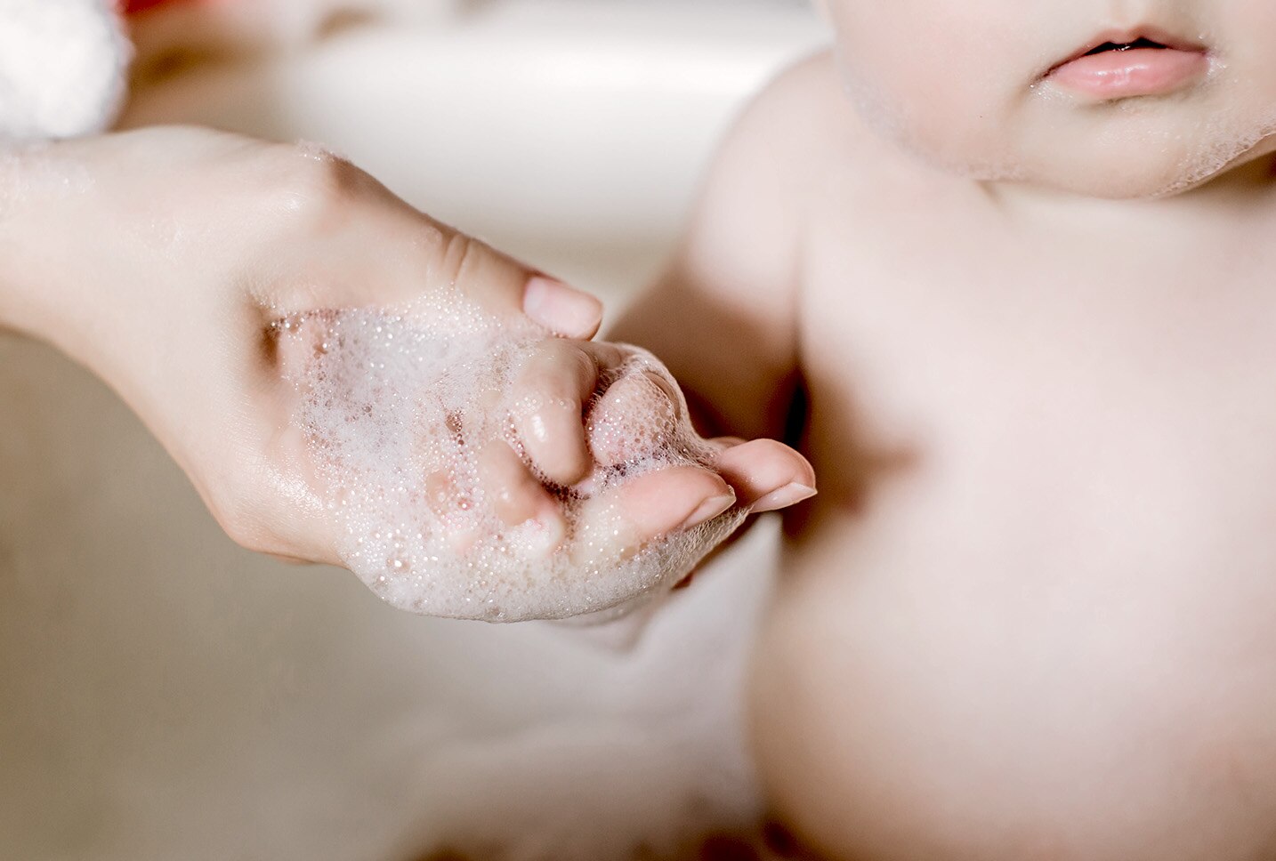 Mujer lavando suavemente las manos del bebe